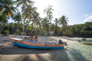 a group of people sitting on a boat on the beach at Dominican Tree House Village in El Valle