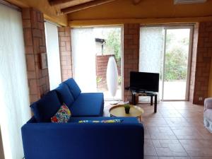 a living room with a blue couch and a tv at Finca Esmeralda in Zahora