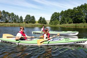 a group of people in kayaks on the water at Port Rybaki & Vine Agritourism in Brodnica