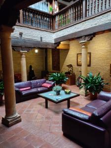 eine Lobby mit Sofas und einem Tisch in einem Gebäude in der Unterkunft HABITACIONES LAS TERMAS in Guadix