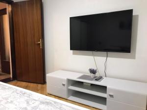 uma cómoda branca com uma televisão de ecrã plano na parede em Apartman Samardžić em Višegrad