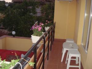 a balcony with potted plants and a table and stool at Family Hotel Central in Kranevo