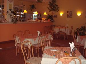 a restaurant with tables and chairs and a bar at Family Hotel Central in Kranevo