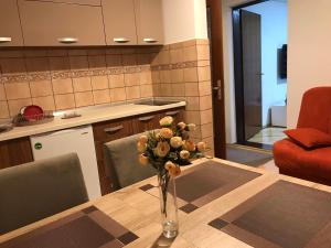 a vase of flowers on a table in a kitchen at Apartman Samardžić in Višegrad