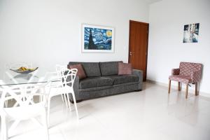 sala de estar con sofá, mesa y sillas en Apartamento 3 Quartos com varanda en Diamantina