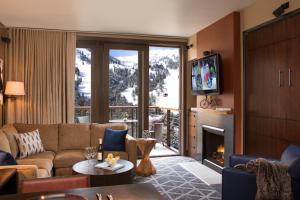 a living room with a couch and a fireplace at Hotel Terra Jackson Hole, a Noble House Resort in Teton Village