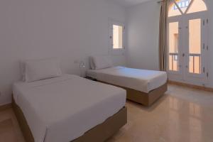A bed or beds in a room at VESTA - El Gouna Residence