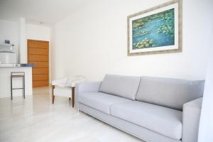 a living room with a couch and a painting on the wall at Apartamento Premium in Diamantina