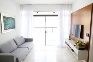 ein Wohnzimmer mit einem Sofa und einem TV in der Unterkunft Apartamento Premium in Diamantina
