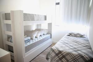 a white bunk bed in a white room with a bed at Apartamento Premium in Diamantina