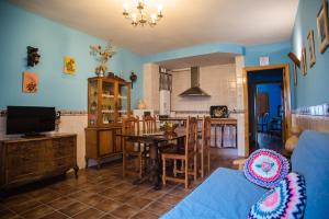 a living room with a table and a kitchen at Alojamientos Rurales La Aldaba in Navalagamella