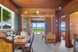 a dining room with a table and a view of the ocean at The Lake Bach - Ngongotaha Lakefront Holiday Home in Ngongotaha