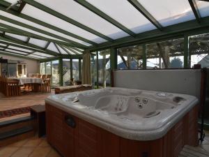 a large bath tub in a room with windows at Lavish Villa in Middelkerke with Sauna in Middelkerke
