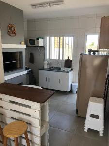 a kitchen with a refrigerator and a table in it at De Boa na Lagoa in São Lourenço do Sul +10 photos