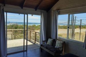 une chambre avec un canapé et un balcon avec vue sur l'océan dans l'établissement La posta de corumba, à La Paloma