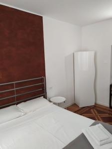 una camera con letto bianco e testiera in legno di Brera a Milano