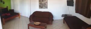 a living room with a chair and a table at Aparthotel BahiaTropical in Canavieiras