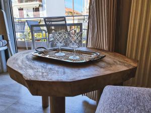 un tavolo con due bicchieri da vino sopra di Kainon Asti a Città di Lefkada