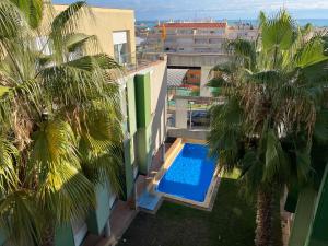 una vista aérea de un edificio con piscina y palmeras en Simancas. Apartamento en zona privilegiada, en Sant Carles de la Ràpita