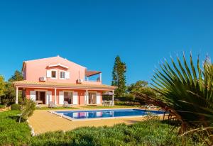 una casa con una piscina di fronte di Villa Sunrise by Algarve Vacation a Carvoeiro