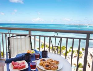 a table topped with plates of food and drinks at Divi Aruba Phoenix Beach Resort in Palm-Eagle Beach