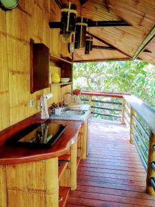 una cocina con fregadero en una terraza de madera en TREEHOUSE PILON PAVONES, en Pavones