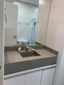 uma casa de banho com um lavatório e um espelho em Suite Turtle no Guarujá