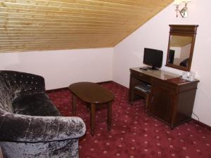 a room with a chair and a desk with a television at Complex Verona Predeal in Predeal