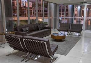 a lobby with a couch and a table in a building at Apart Hotel Fusion Estacionamento Grátis A007 in Brasilia