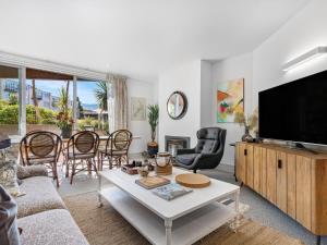a living room with a television and a table at Maison de Charme Central Apartment in Queenstown