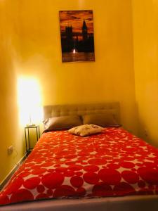 - une chambre avec un lit et une couette rouge dans l'établissement The Beautiful Italian Suit, à Vienne