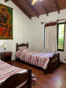 a bedroom with two beds and a painting on the wall at Chalet Individual Maiten 1 in Merlo