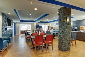 a restaurant with tables and chairs and a stone pillar at Holiday Inn Express Hotel & Suites Dayton-Centerville by IHG in Centerville