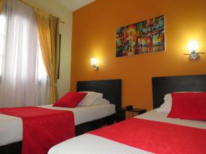 Habitación de hotel con 2 camas en rojo y blanco en Hotel La Herreria Colonial, en Popayán