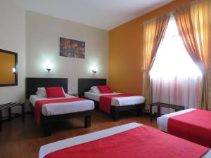 um quarto de hotel com duas camas e uma janela em Hotel La Herreria Colonial em Popayan