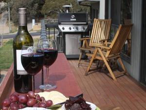 una mesa con dos copas de vino y un plato de comida en Boronia 7 30 Nettin Circuit, en Jindabyne