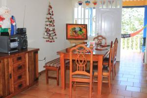 une salle à manger avec une table, des chaises et un arbre de Noël dans l'établissement Casa el Colibrí, Finca Cerros de Payuco, à Fresno