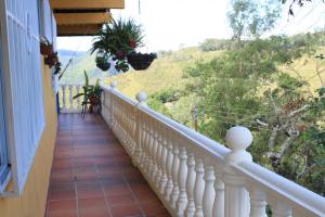 - un balcon d'une maison avec une balustrade blanche dans l'établissement Casa el Colibrí, Finca Cerros de Payuco, à Fresno