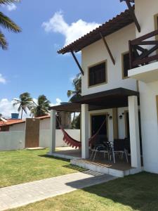 a large white house with a patio and grass at Morada dos Cataventos (Frente Mar) in Barra de Camaratuba