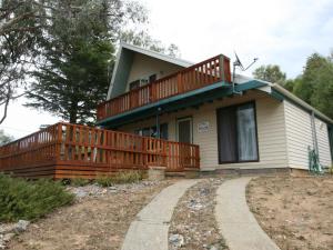 a house with a large deck on the side of it at 14 Cobbon Crescent in Jindabyne