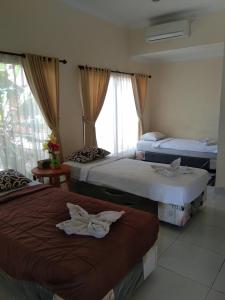 um quarto de hotel com duas camas e uma janela em SunwuKong Guest House em Ubud