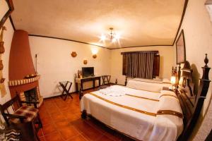 sypialnia z 2 łóżkami i telewizorem w obiekcie Hotel Posada de Don Rodrigo Panajachel w mieście Panajachel