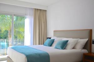 a bed in a hotel room with a large window at Lincoln Green Hotel and Spa - ARGENTINA in Lincoln