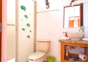 ein Badezimmer mit Toilette, Waschbecken und Spiegel in der Unterkunft Family Home close to the Beach, Vidanta, Aqua Adventures with Pool & Parking in Nuevo Vallarta + 28 Fotos