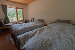 Кровать или кровати в номере Forest Lodge -1 group only, 3 bed rooms & wide open space with superb mountain view-Niseko GURUGULU