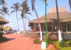 ein Gebäude mit Palmen vor einem Strand in der Unterkunft Family Home close to the Beach, Vidanta, Aqua Adventures with Pool & Parking in Nuevo Vallarta