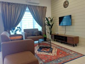 ein Wohnzimmer mit einem Sofa und einem TV in der Unterkunft As Syifaa Homestay Mslim only in Ipoh