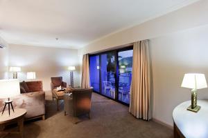 a hotel room with a couch and a living room with a window at Quadas Hotel - Adult Only in Marmaris