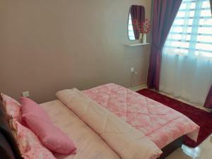 1 dormitorio con cama con sábanas rosas y ventana en As Syifaa Homestay Mslim only en Ipoh