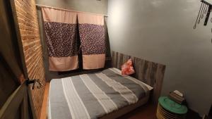 a small bedroom with a bed and a curtain at 途中玉里青年旅舍On My Way Yuli Hostel in Yuli